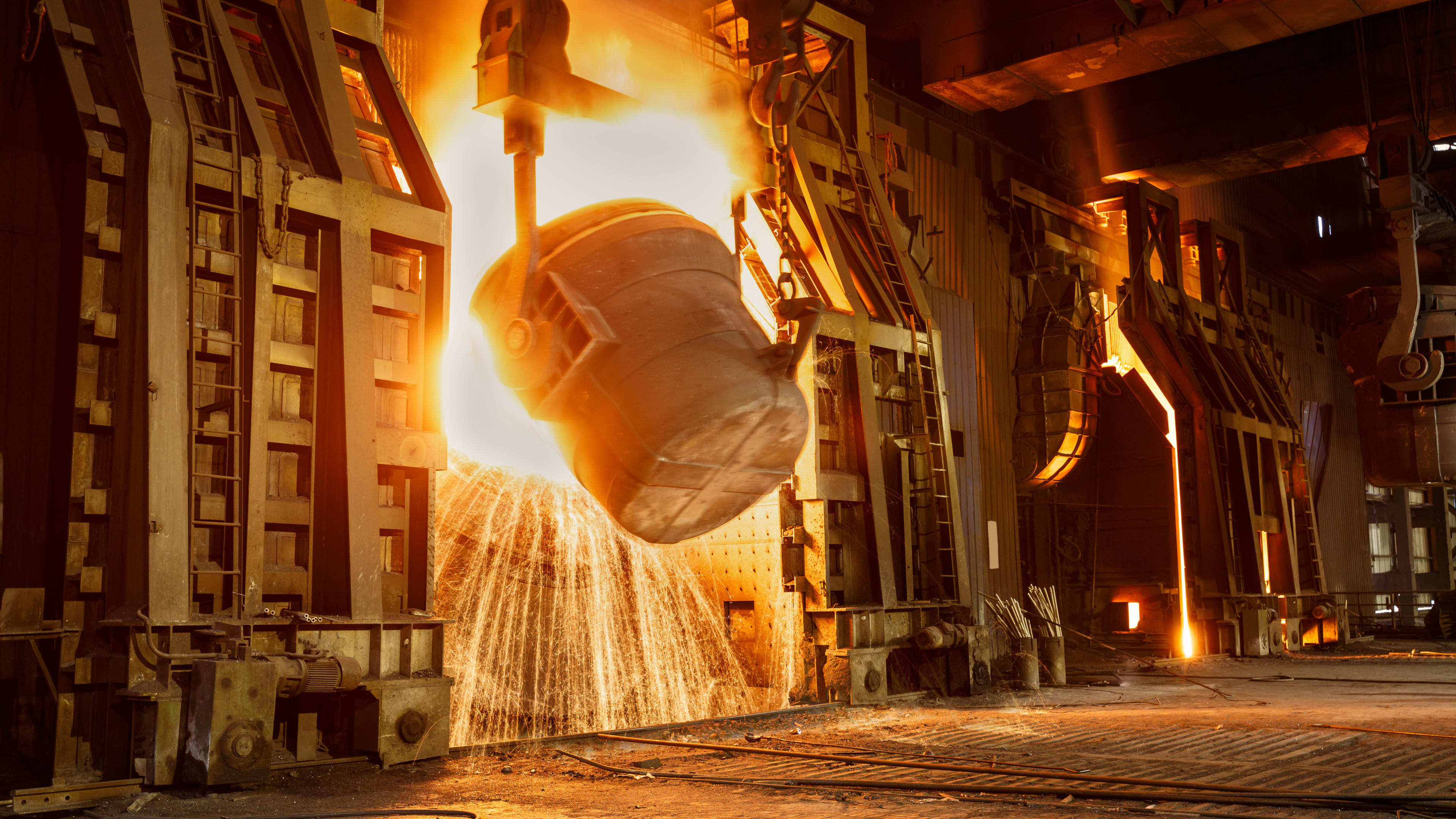 Molten steel being poured from a ladle in an AOD-BOF process at a steel plant.
