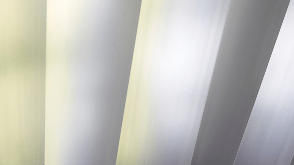 Close-up view of galvanized steel sheets with a reflective zinc coating, used in industrial manufacturing.