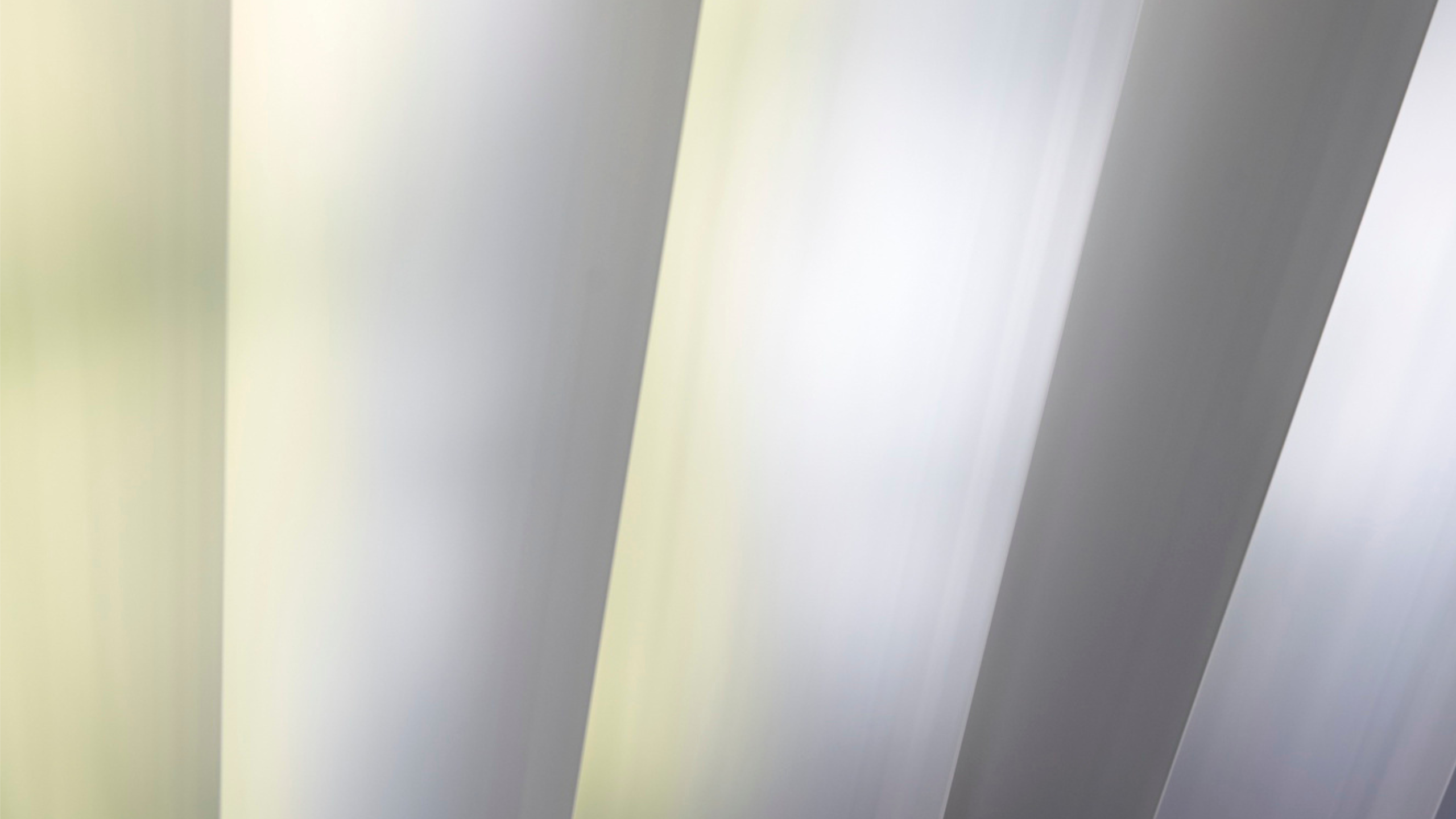 Close-up view of galvanized steel sheets with a reflective zinc coating, used in industrial manufacturing.